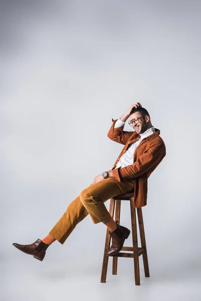 Alegre Homem Elegante Sentado Cadeira Madeira Fundo Cinza — Fotografia de Stock