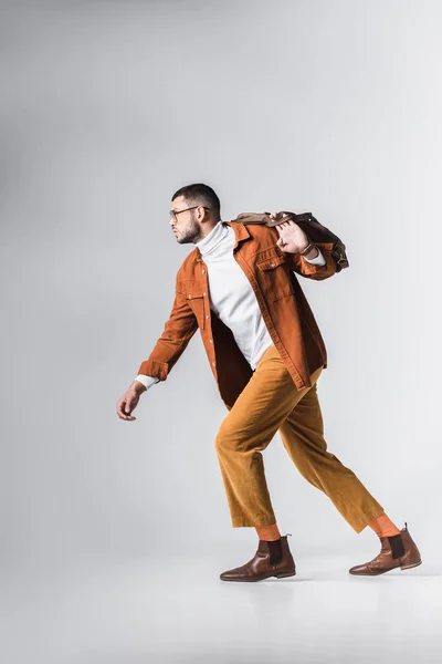 Fashionable Man Eyeglasses Holding Brown Bag While Running Grey Background — Stock Photo, Image