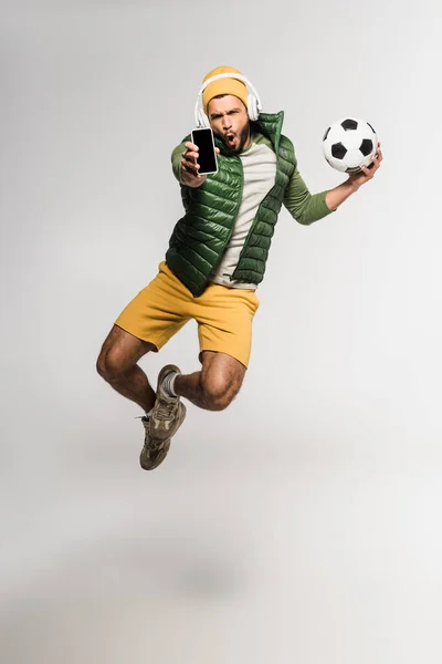 Deportista Entusiasmado Con Auriculares Que Sostienen Fútbol Muestran Teléfono Inteligente —  Fotos de Stock