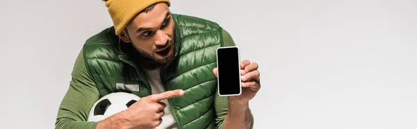 Deportista Emocionado Con Fútbol Apuntando Con Dedo Teléfono Inteligente Aislado — Foto de Stock