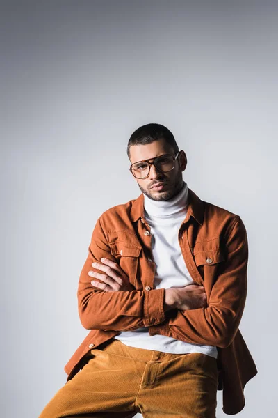 Fashionable Man Eyeglasses Looking Camera Crossed Arms Grey Background — Stock Photo, Image