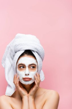 sad beautiful woman with towel on head and clay mask on face isolated on pink clipart