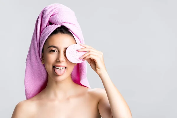 Piękna Kobieta Ręcznikiem Włosach Trzyma Gąbkę Pokazuje Język Odizolowany Szarości — Zdjęcie stockowe