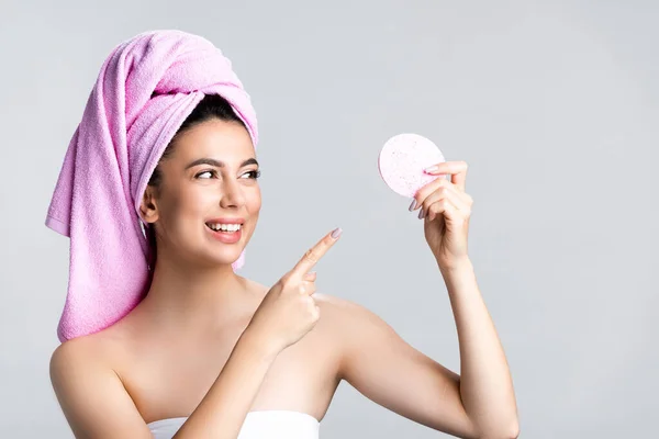 Uśmiechnięta Piękna Kobieta Ręcznikiem Włosach Wskazującym Gąbkę Odizolowaną Szaro — Zdjęcie stockowe