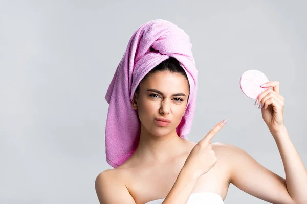 Niezadowolona Piękna Kobieta Ręcznikiem Włosach Wskazującym Gąbkę Odizolowaną Szaro — Zdjęcie stockowe
