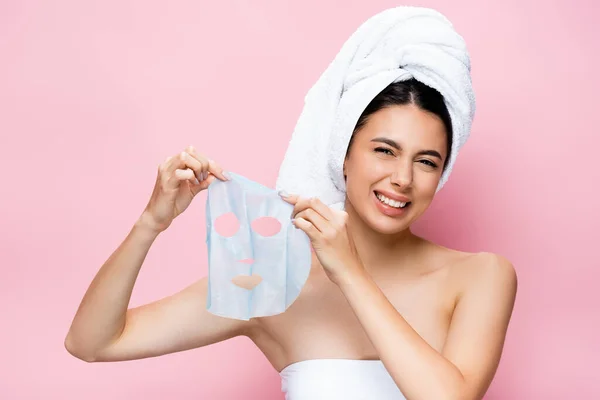 Walgelijke Mooie Vrouw Met Handdoek Hoofd Holding Masker Blad Geïsoleerd — Stockfoto