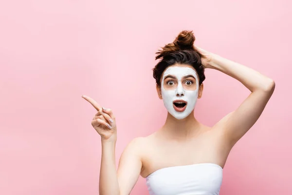 Shocked Beautiful Woman Clay Mask Face Pointing Aside Isolated Pink — Stock Photo, Image