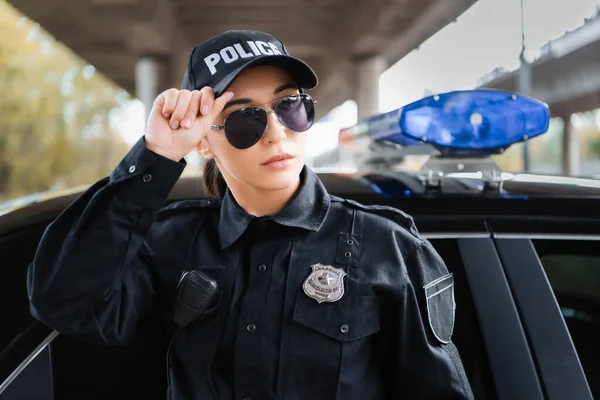 Jonge Politievrouw Kijkt Weg Buurt Van Politie Auto Wazig Achtergrond — Stockfoto