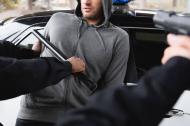 Ön planda silah doğrultulan bulanık meslektaşı olan ve elinde copuyla saldırganı tutuklayan Afro-Amerikan polisinin...