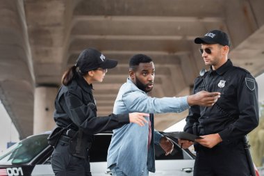 Afro-Amerikalı kurban, şehir sokaklarının bulanık geçmişinde polis memurlarının yakınlarını işaret ediyor.