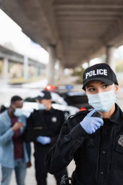 Tıbbi maskeli bir kadın, Afrika kökenli Amerikalı bir kurban ve meslektaşının yakınındaki traş telsizini kullanarak şehir sokaklarının bulanık geçmişini araştırıyor. 