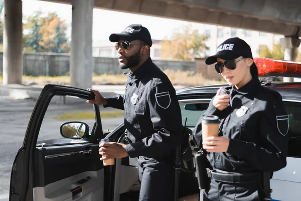 Seriózní Africký Americký Policista Odvrací Pohled Poblíž Kolega Mluví Rádiu — Stock fotografie