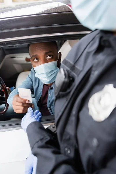 African American Driver Medical Mask Giving License Policeman Blurred Foreground — Stock Photo, Image