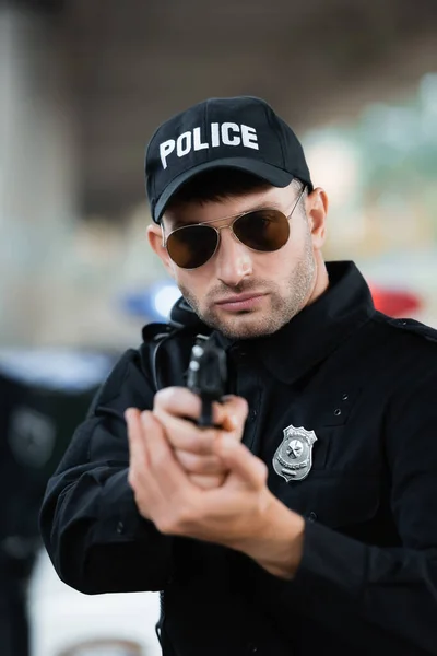 Politieagent Uniform Zonnebril Met Pistool Wazig Voorgrond Buiten — Stockfoto