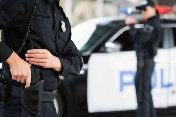 Policeman Taking Gun Holster Colleague Car Blurred Background — Stock Photo, Image