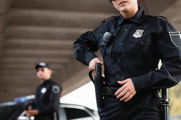 Mujer Policía Tomando Arma Fuego Funda Cerca Colega Fondo Borroso —  Fotos de Stock