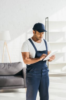 Dairesinde dijital tablet kullanan üniformalı Hintli işçi 