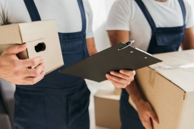 Dairede karton kutular taşıyan nakliyecilerin kırpılmış görüntüsü 