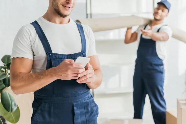 Handyman Med Smartphone Nära Indian Mover Suddig Bakgrund — Stockfoto