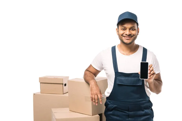 开开心心的印地安人搬运工 身穿工作服 手持智能手机 在盒子旁边的空白屏风下 白色隔离开 — 图库照片