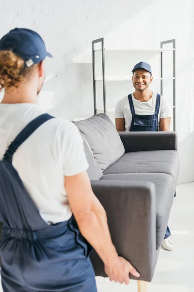 Happy Indian Mover Carrying Sofa Colleague Blurred Foreground — Stock Photo, Image