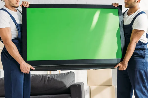 Cropped View Multicultural Movers Uniform Carrying Plasma Green Screen Apartment — Stock Photo, Image