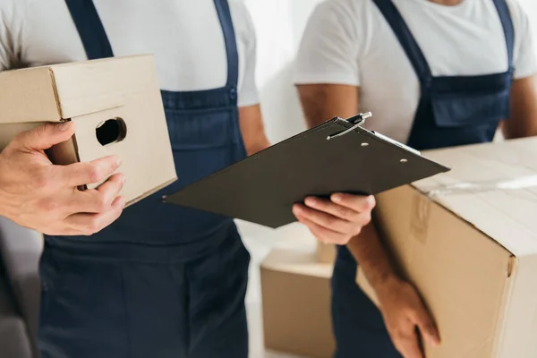 Vue Recadrée Des Déménageurs Tenant Des Boîtes Carton Dans Appartement — Photo