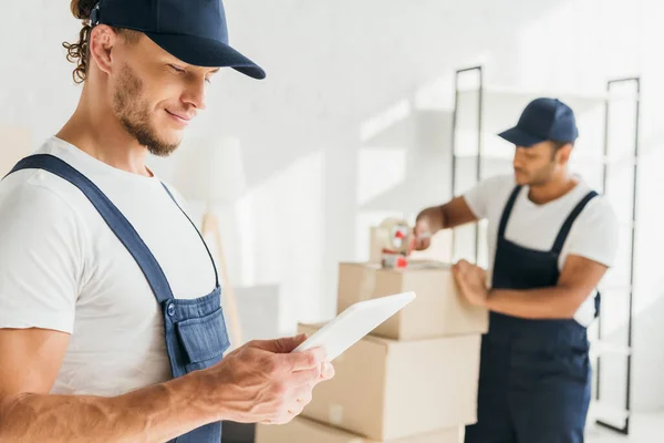 Glimlachende Werknemer Uniform Houden Digitale Tablet Buurt Van Indiase Collega — Stockfoto