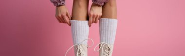 cropped view of female legs in boots and socks on pink background, banner clipart