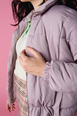 Pembe arka planda şık kabarık ceketli genç kadın manzarası