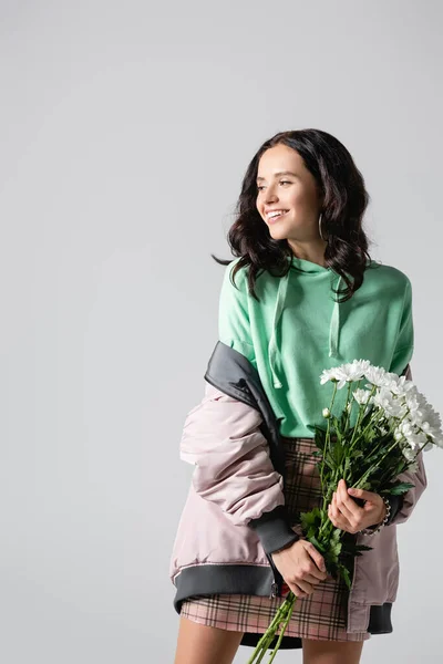 Usmívající Brunetka Mladá Žena Stylové Zimní Oblečení Pózování Květinami Šedém — Stock fotografie