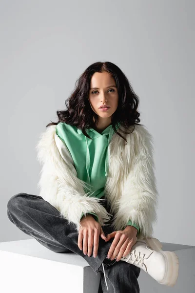 Brunette Jonge Vrouw Faux Fur Jas Poseren Kubus Witte Achtergrond — Stockfoto