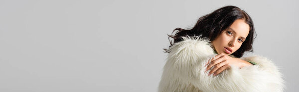 brunette young woman in faux fur jacket posing on white background, banner