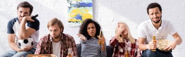 upset african american woman pointing with hand while watching football championship with sad multicultural friends, banner clipart