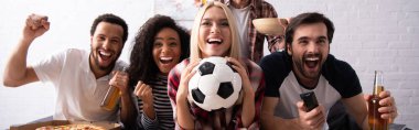 cheerful woman holding soccer ball while watching championship with excited multiethnic friends, banner clipart