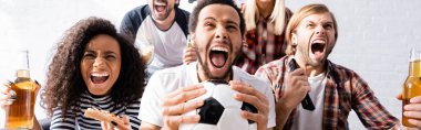 excited multiethnic friends screaming while watching football championship at home, banner clipart