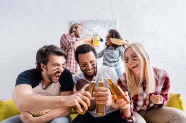 Heyecanlı adam bağırıyor. Bira şişelerini boyalı yüzlü çok kültürlü arkadaşlarla tokuştururken.