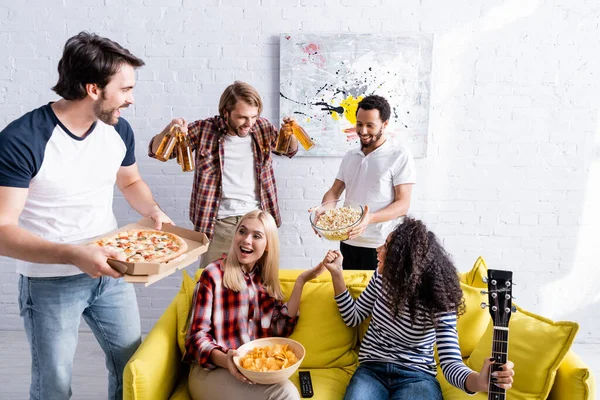 Hombres Multiculturales Sosteniendo Cerveza Pizza Palomitas Maíz Cerca Las Mujeres — Foto de Stock