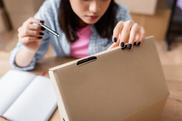 Cropped View Woman Pointing Pen While Opening Carton Box Blurred — Stock Photo, Image