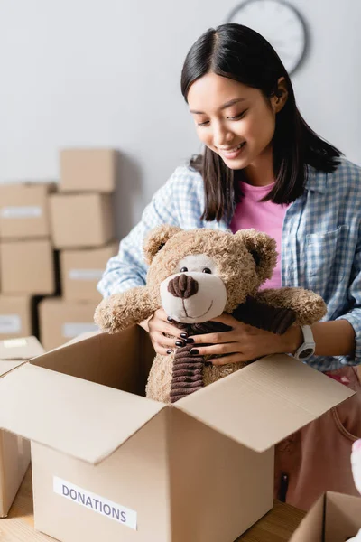 Alegre Asiático Voluntário Colocando Brinquedo Macio Caixa Papelão Com Doações — Fotografia de Stock