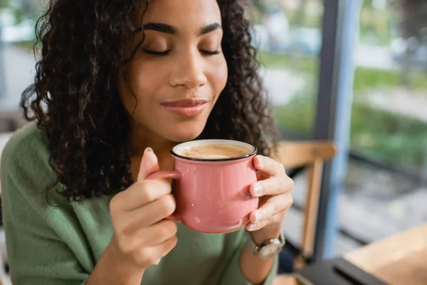 Mujer Afroamericana Complacida Oliendo Café Con Leche Taza —  Fotos de Stock