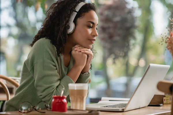 Afro Amerikan Kadın Podcast Dinliyor Kafede Dizüstü Bilgisayara Bakıyor — Stok fotoğraf