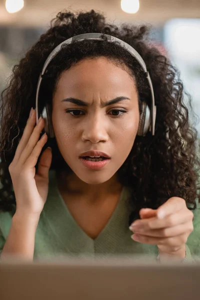 Mujer Afroamericana Sorprendida Escuchando Podcast Señalando Con Dedo Cafetería — Foto de Stock