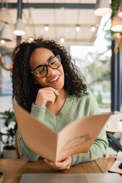 Feliz Rizado Africano Americano Mujer Gafas Celebración Menú Borrosa Primer —  Fotos de Stock