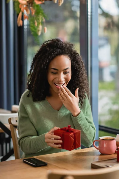 Mulher Americana Africana Espantado Segurando Caixa Presente Natal Vermelho Café — Fotografia de Stock