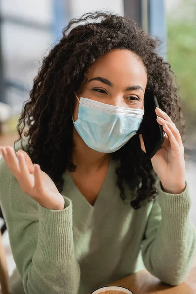 Curly African American Woman Medical Mask Talking Smartphone Cafe — Stock Photo, Image