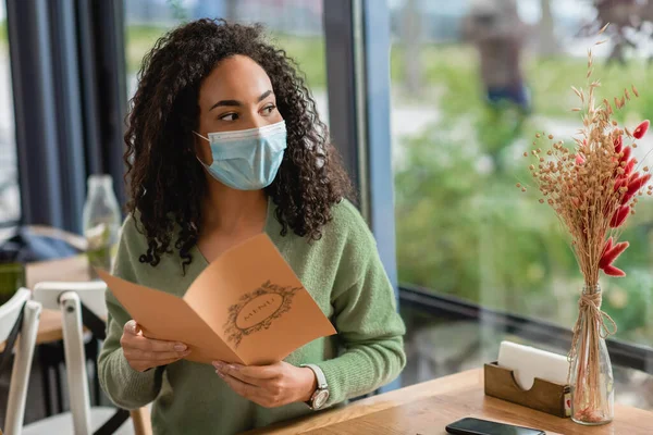 African American Woman Medical Mask Holding Menu Looking Away Cafe — Stock Photo, Image