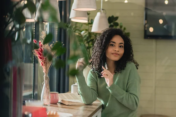 Mujer Afroamericana Sosteniendo Anteojos Mirando Cámara Café —  Fotos de Stock