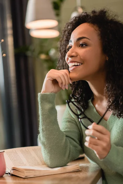 Zâmbind African American Femeie Care Deține Ochelari Cafenea — Fotografie, imagine de stoc