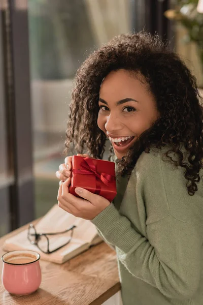 Joyful African American Woman Holding Wrapped Christmas Present Cafe — Stock Photo, Image